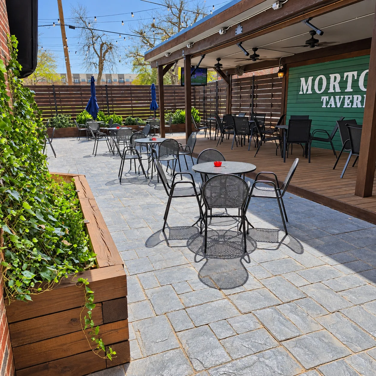 Dog-friendly patio seating with planters at Morton's Tavern in Fort Worth