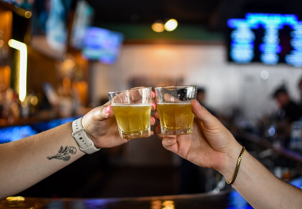 Two friends toasting with shots at the Morton's Tavern bar in Fort Worth
